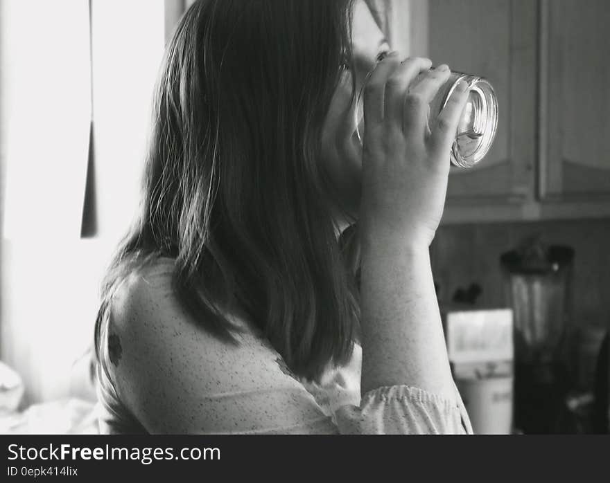 Grayscale Photo of Lady Drinking Water