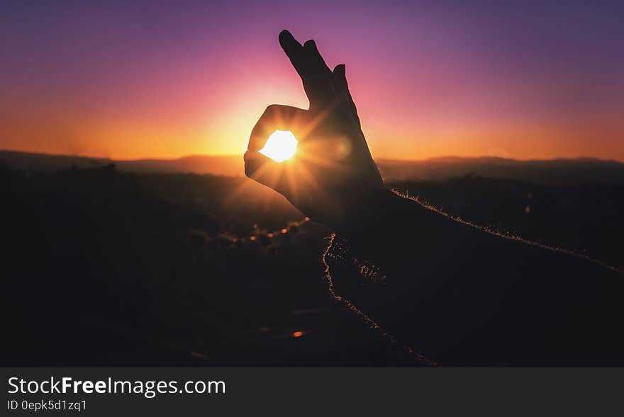 Person Doing Ok Hand Sign during Sunset