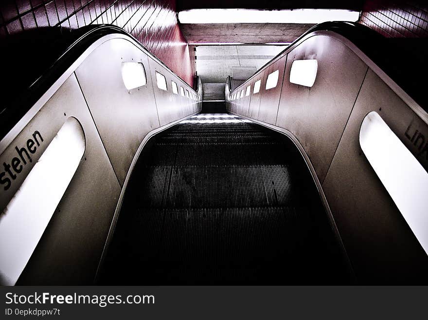 Black Escalator Near Red Wall Tiles