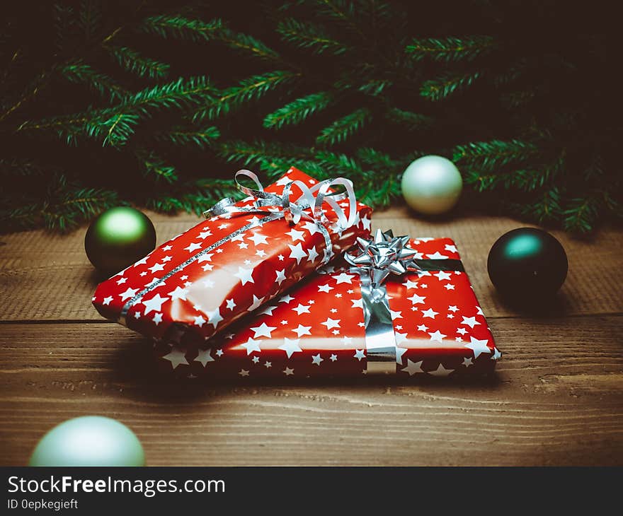 Christmas presents in red and silver wrapping paper and bows under Christmas tree with ornaments. Christmas presents in red and silver wrapping paper and bows under Christmas tree with ornaments.