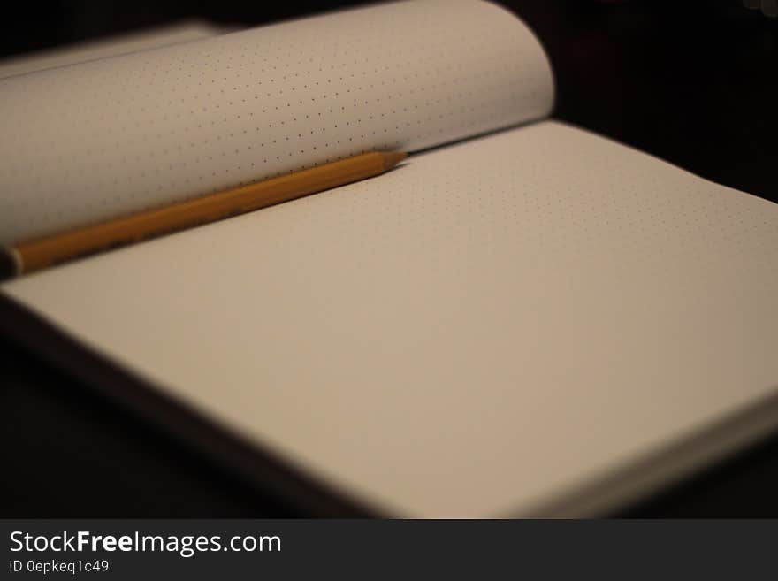 Close up of blank pages in notebook with pencil. Close up of blank pages in notebook with pencil.