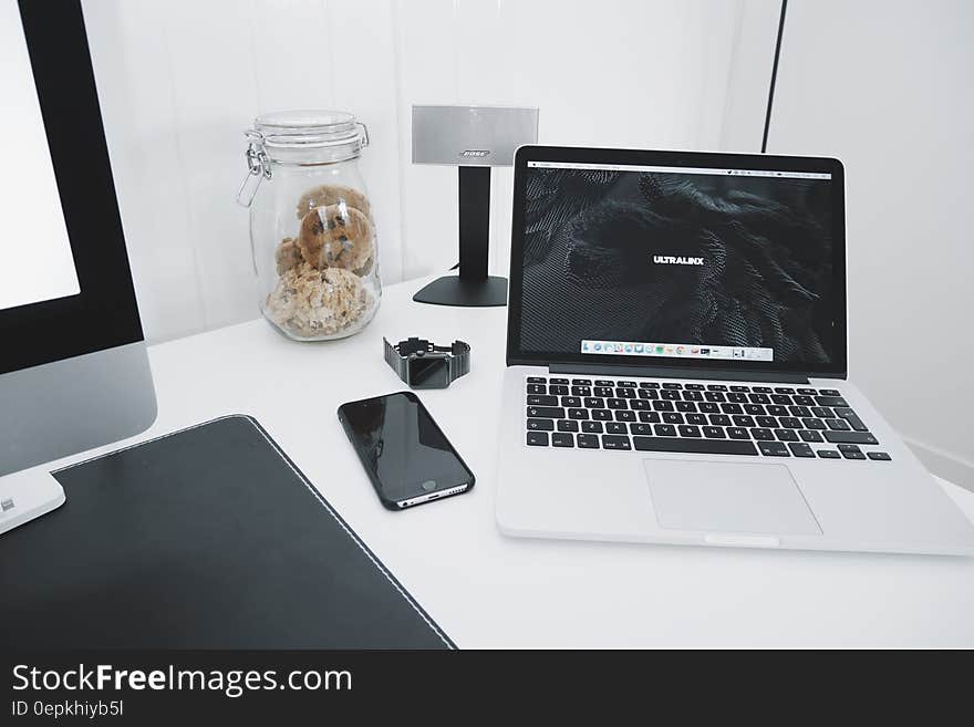 Computer laptop and monitor with smartphone on white desktop. Computer laptop and monitor with smartphone on white desktop.