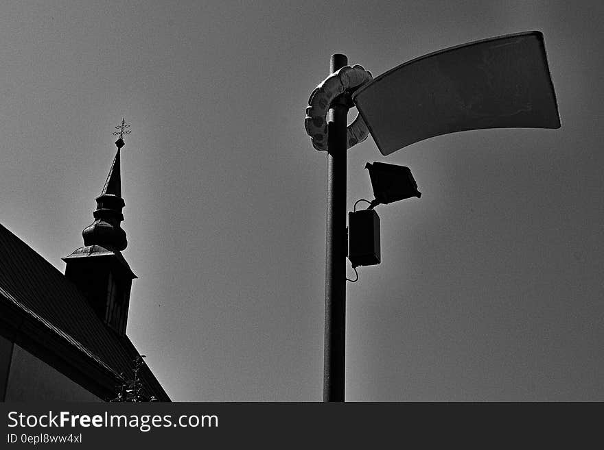 Black and white gritty urban skyline with pole and spire.