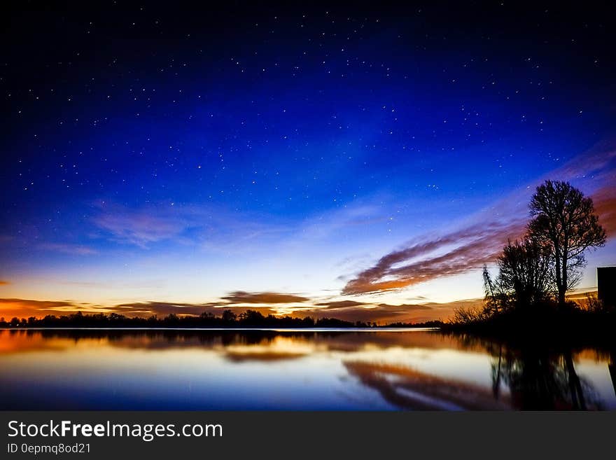 Sunset over reflecting lake with stars in sky. Sunset over reflecting lake with stars in sky.