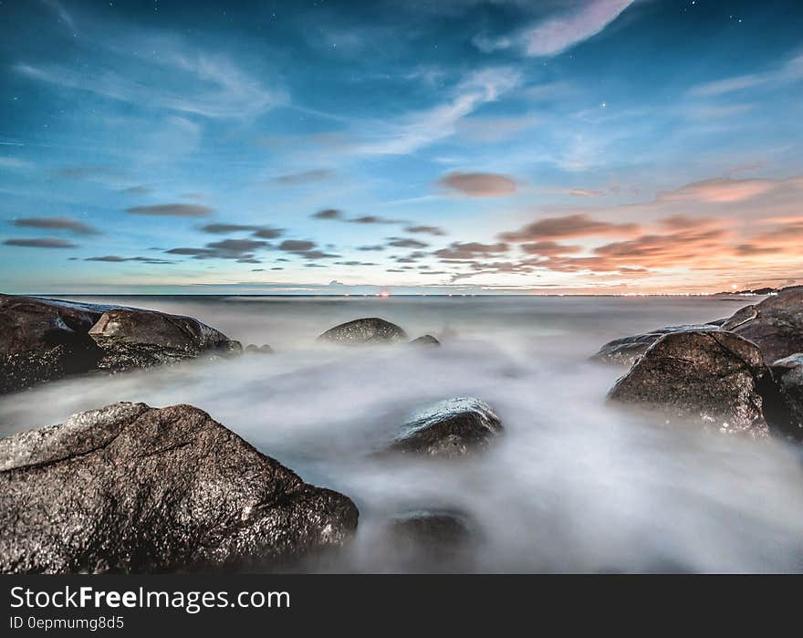 Blur of water creating fog over rocky coastline at sunrise. Blur of water creating fog over rocky coastline at sunrise.