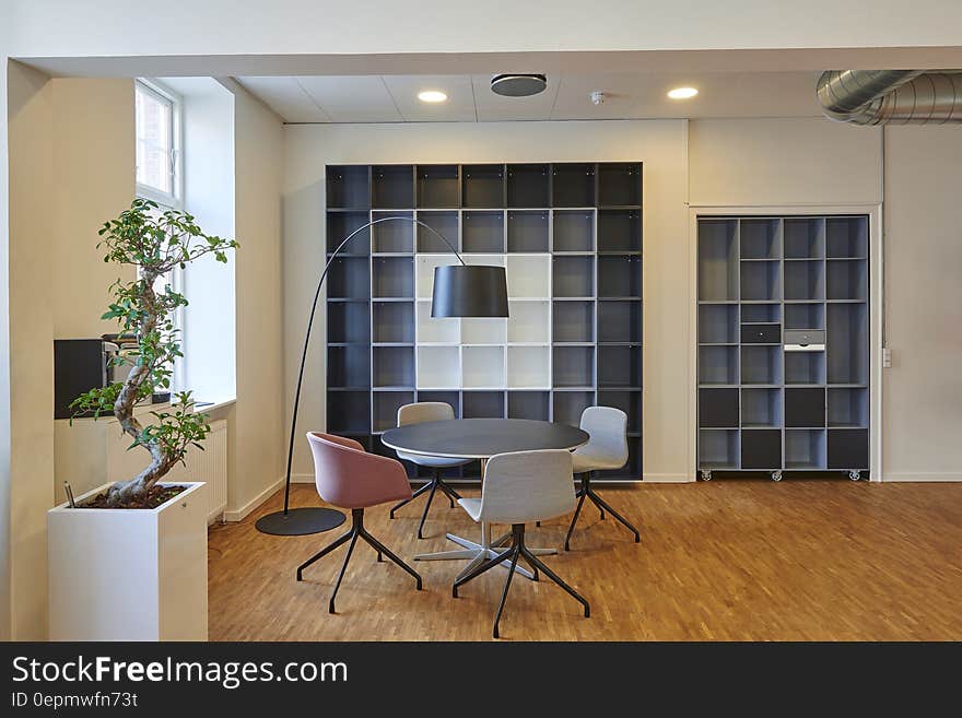 Interior of living room with built in book shelves, table and chairs and sunny window. Interior of living room with built in book shelves, table and chairs and sunny window.