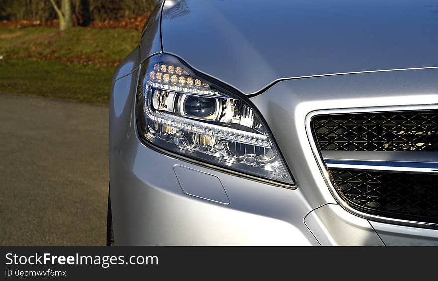 Close up of headlamp and fender on silver car. Close up of headlamp and fender on silver car.