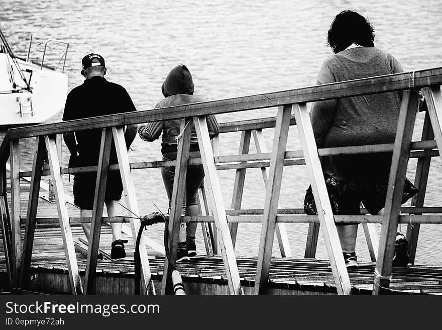 3 Person Walking on Bridge Black and White Photo