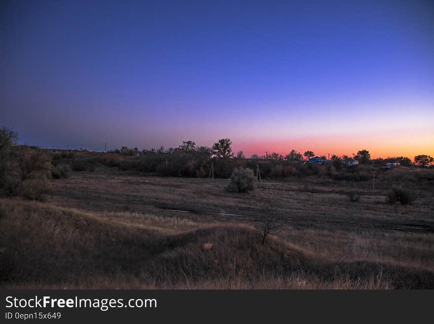 Sunset over rural fields with blue skies. Sunset over rural fields with blue skies.