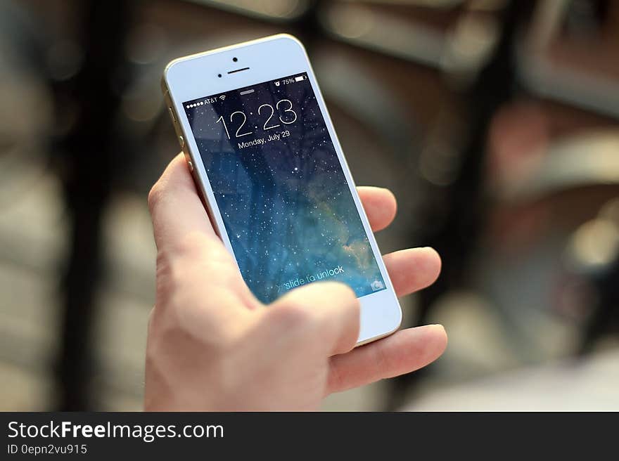 A close up of a hand holding an iPhone. A close up of a hand holding an iPhone.