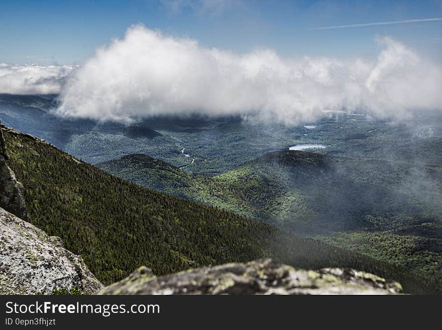 A view of mountain slopes covered in thick forest from the mountain top. A view of mountain slopes covered in thick forest from the mountain top.