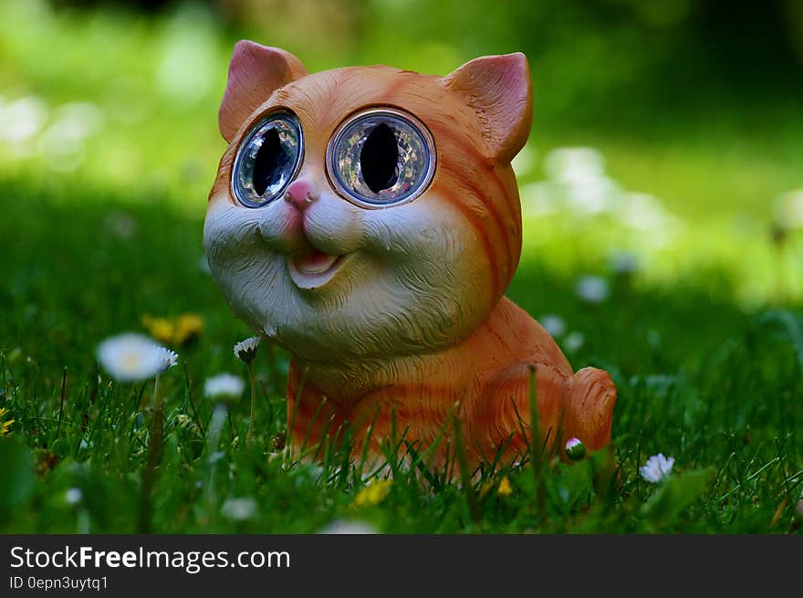 Yellow and Orange Tabby Kitten Figurine on Green Grass Plant