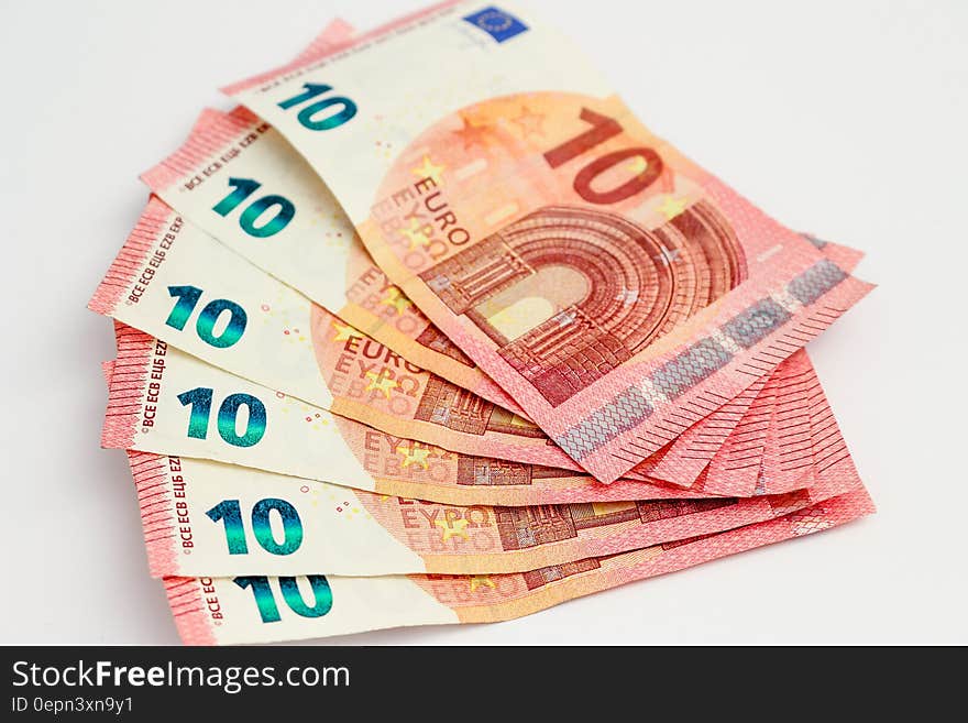 Stack of 10 Euro notes on white.