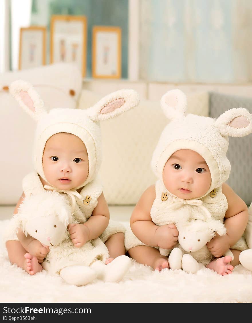 2 Babies Wearing White Headdress White Holding White Plush Toys