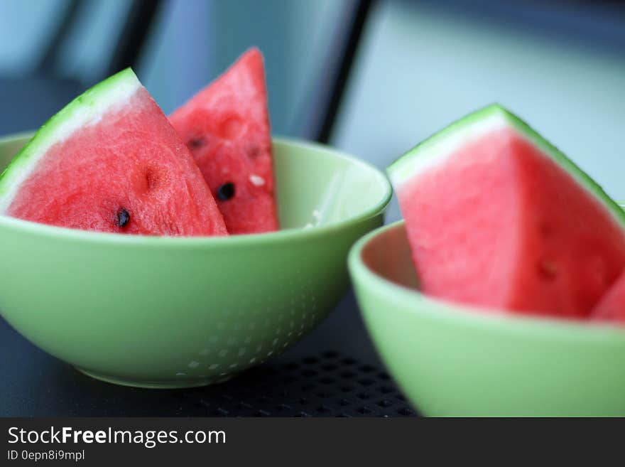 A close up of pale green fruit bowls with watermelon slices.