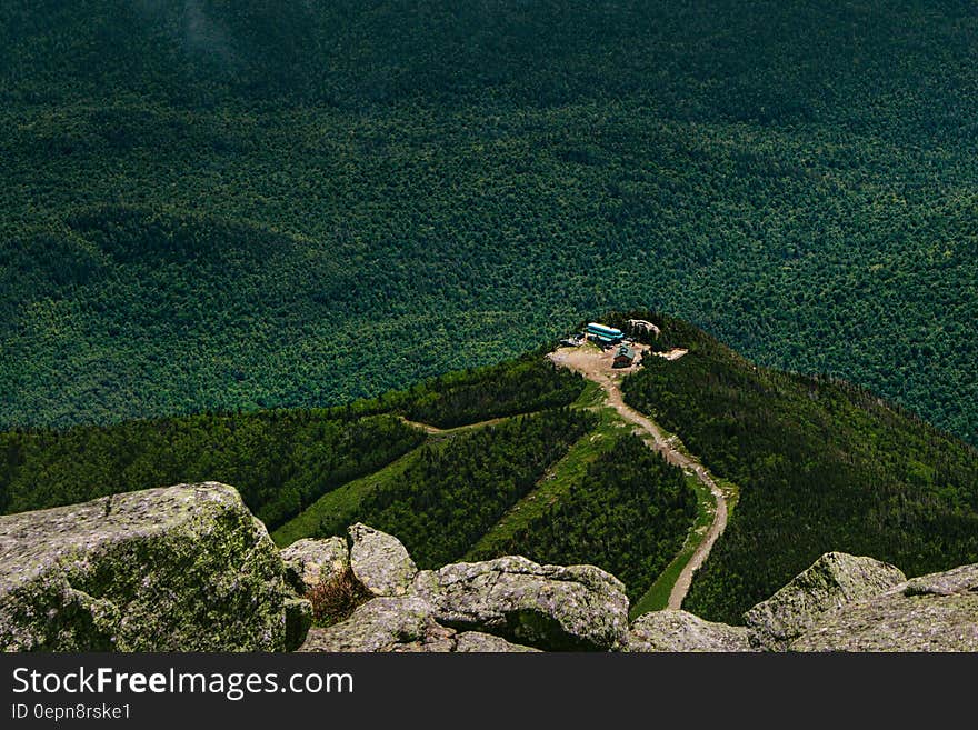 A view of a lonely house on a hill top surrounded by forest. A view of a lonely house on a hill top surrounded by forest.