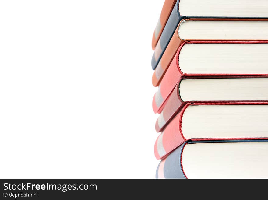 Tall pile of books with white paper (pages) and red and blue bindings, arranged to leave blank space for added text or advertising.