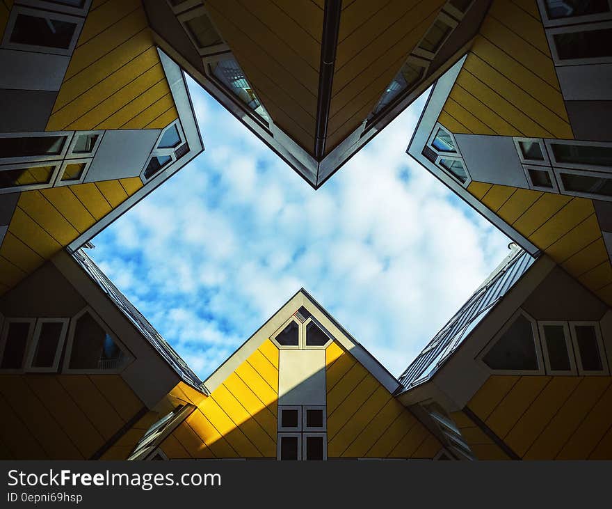 Low Angle Photo of Yellow Wall Paint Building Under White Sky at Daytime