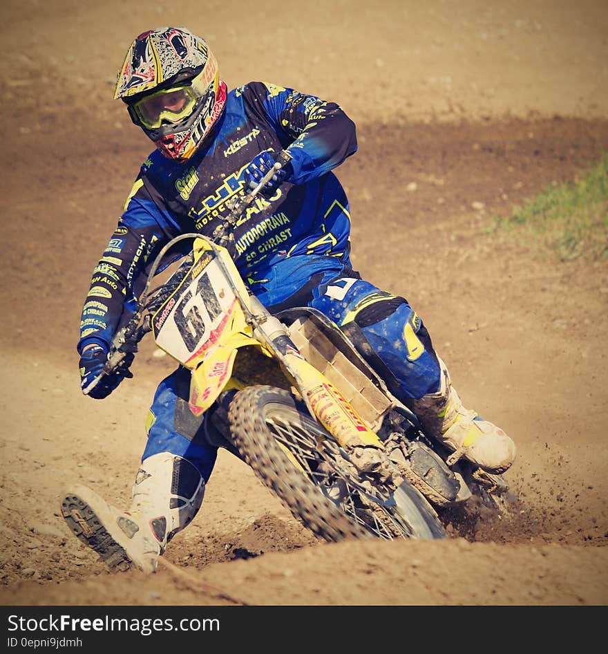 Man in Blue Motorcycle Suit Riding on Yellow Dirt Motorcycle during Daytime