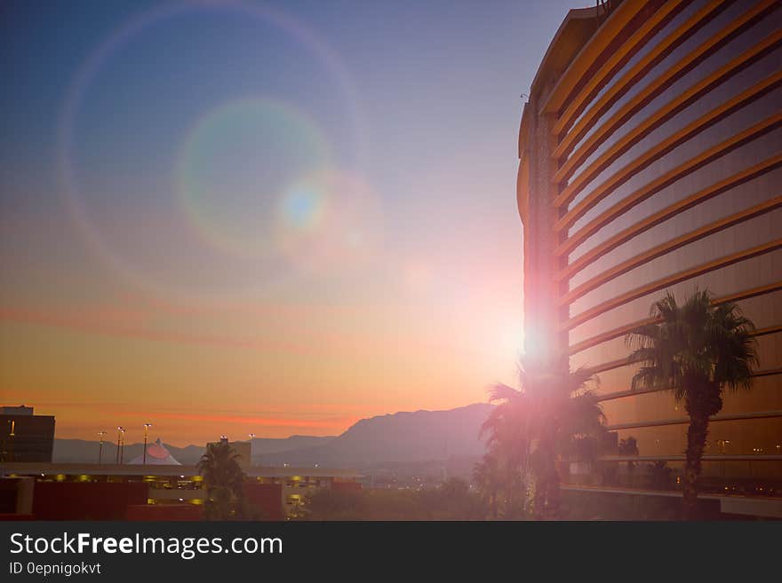 Sunset behind modern building with palm trees. Sunset behind modern building with palm trees.