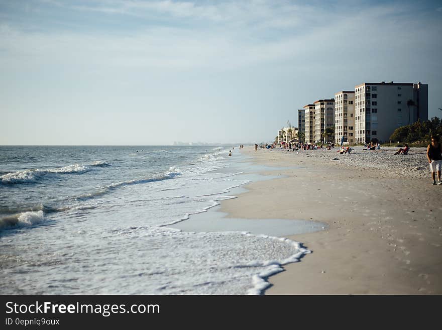 White Cloudy Sky over Seashore With Buildings during Daytime