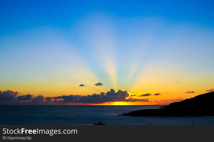 Sunset in blue skies over coastline. Sunset in blue skies over coastline.