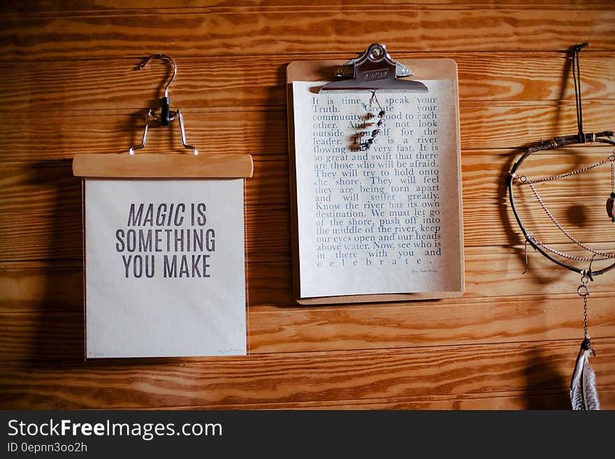 Clipboards on wooden wall with printed text and dream catcher. Clipboards on wooden wall with printed text and dream catcher.