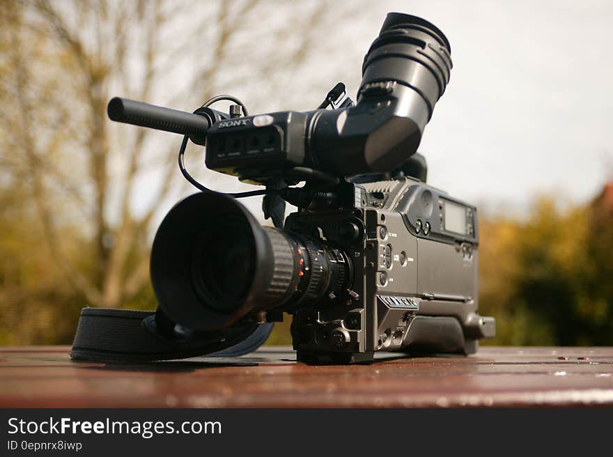 Black Video Camera on Brown Wooden Table