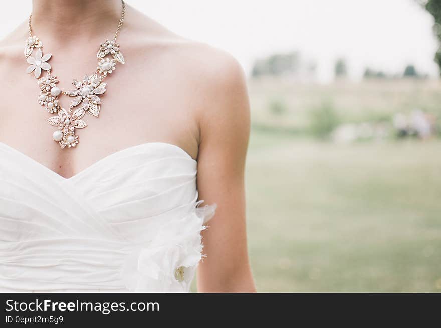 Woman in White Dress Wearing Gold Chunky Necklace during Daytime