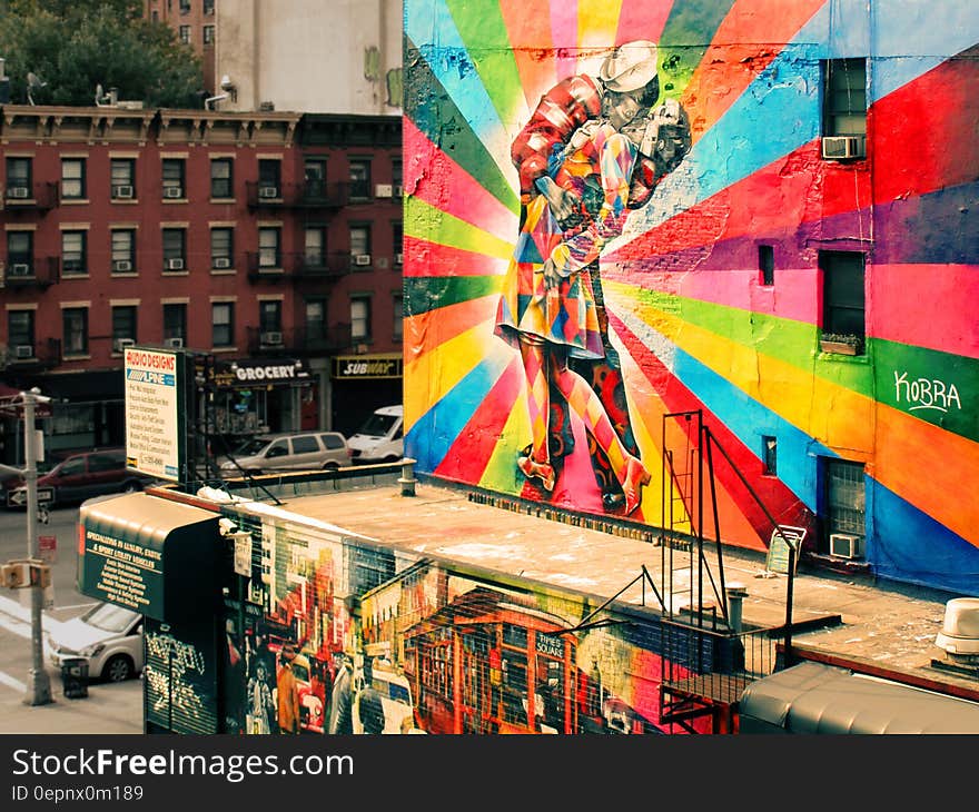 A view of a city with the side of a building painted with a picture of V-J Day in Times Square. A view of a city with the side of a building painted with a picture of V-J Day in Times Square.