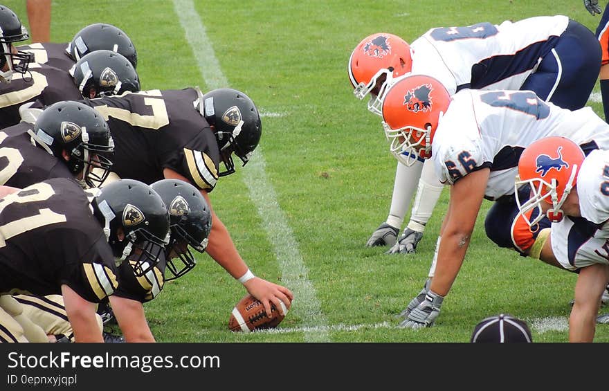 Two American football teams facing off at snap on the field. Two American football teams facing off at snap on the field.