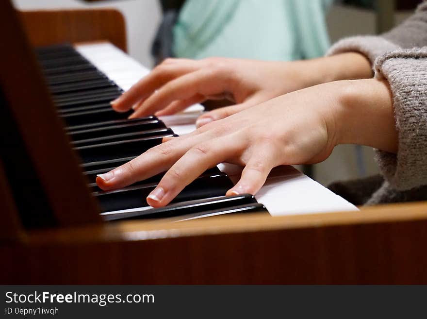 A piano player's hands on the piano keys.