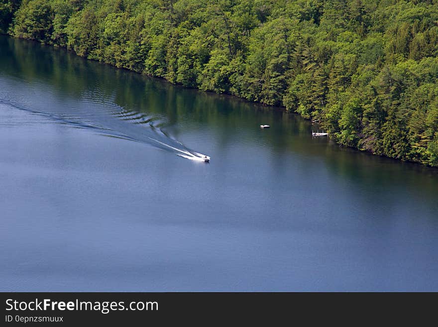 A boat passing through a river on a sunny day. A boat passing through a river on a sunny day.