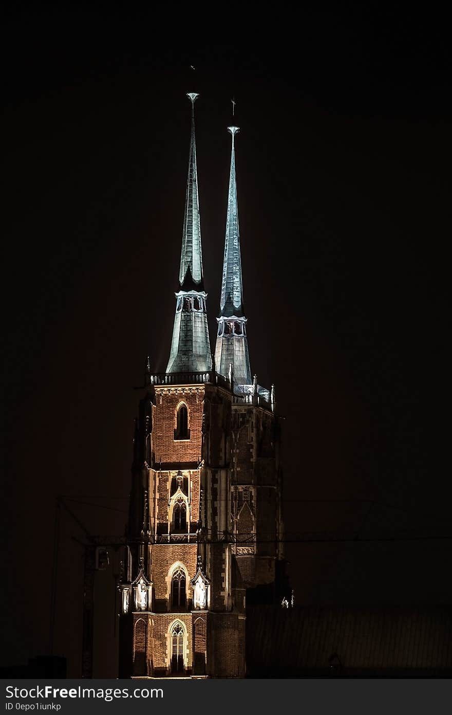 Spires of brick building illuminated against night skies. Spires of brick building illuminated against night skies.