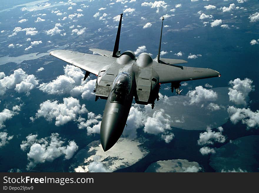 Gray Fighter Jet in White Clouds