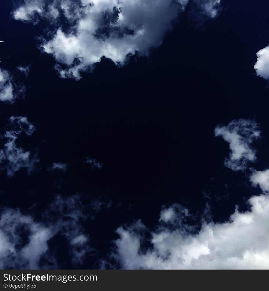 A dark blue sky with white clouds. A dark blue sky with white clouds.