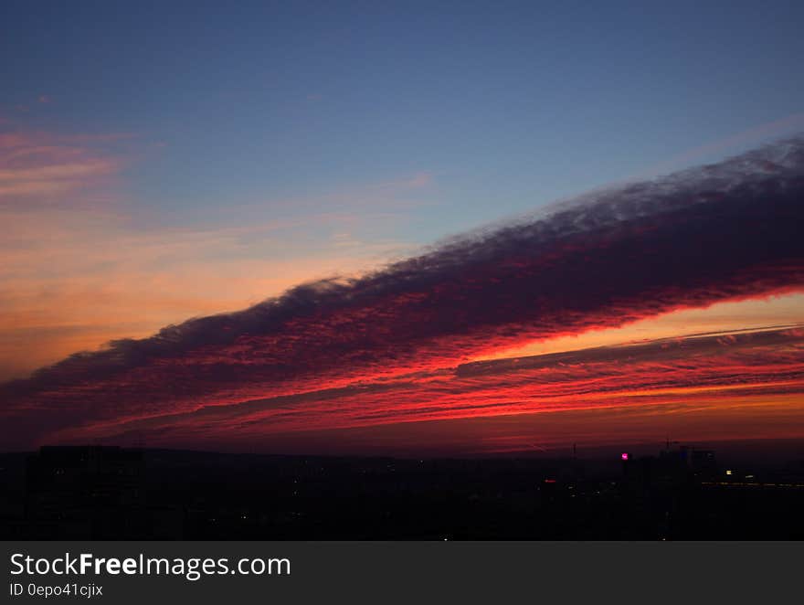 Sunset in cloudy skies over horizon.