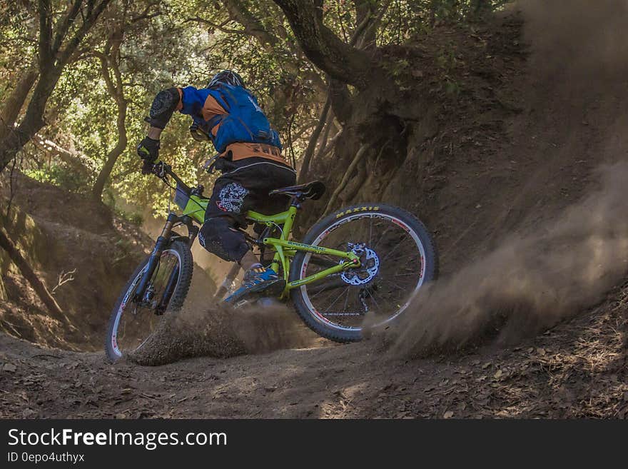 Man in Black and Orange Bicycle Riding Jacket With Green Off Road Bike