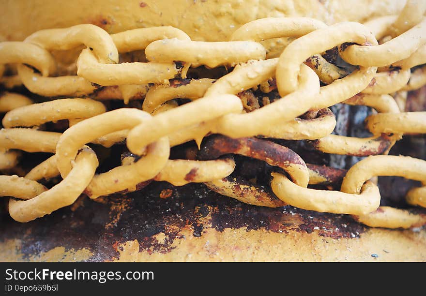 Rusty yellow painted metal chain links. Rusty yellow painted metal chain links.