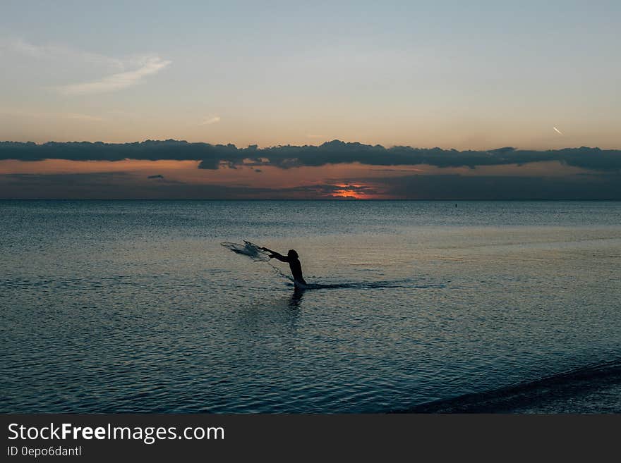 Person on Water Under Blue Sky during Daytime