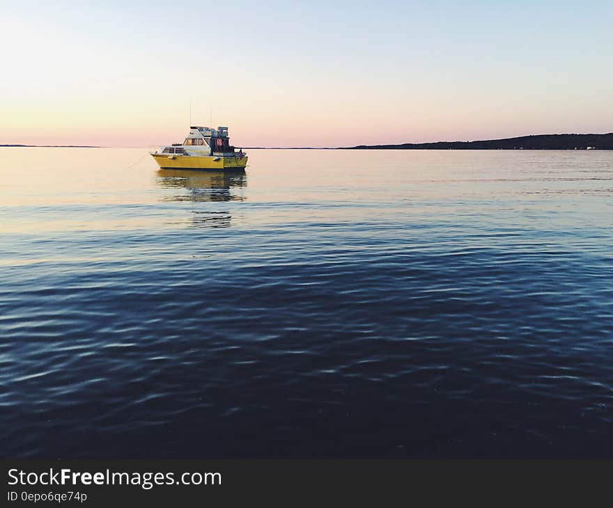 Boat on waters reflecting sunset on horizon. Boat on waters reflecting sunset on horizon.