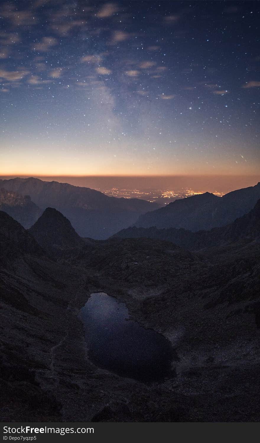 Crater Between Mountains Under Blue Sky White Clouds and Stars during Sunset