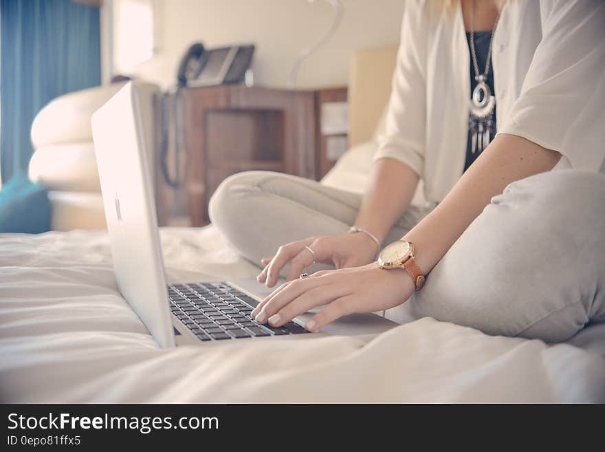 Portrait of woman sitting on bed using laptop computer. Portrait of woman sitting on bed using laptop computer.