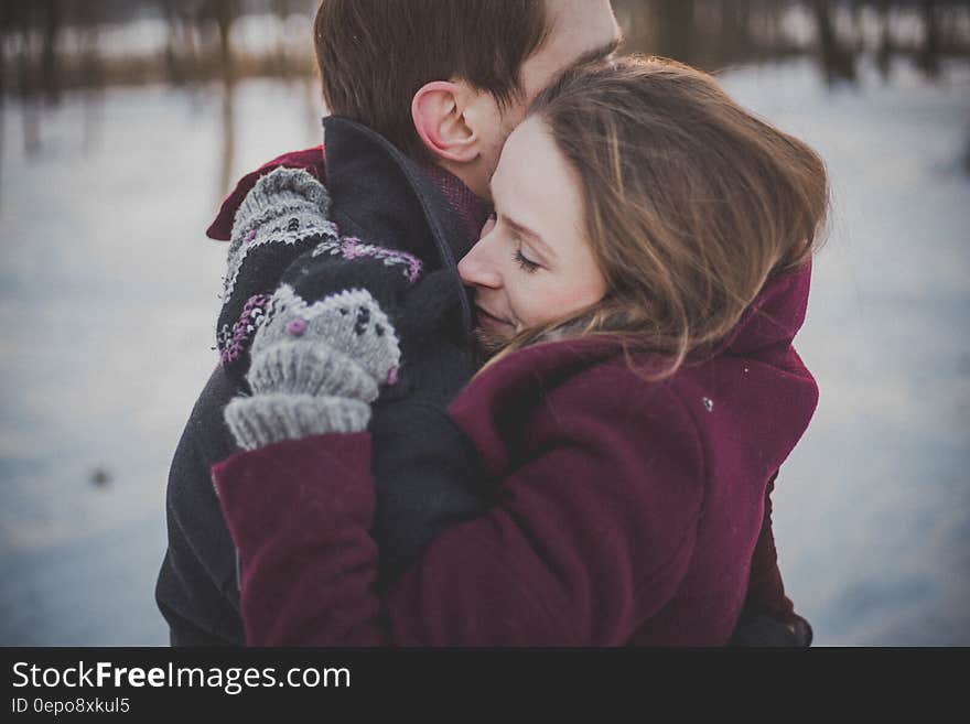 Couple in winter coats embracing in snowy field. Couple in winter coats embracing in snowy field.