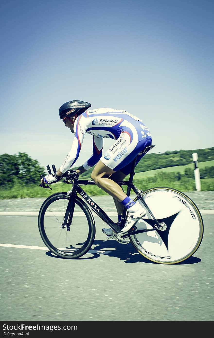 Cyclist on Gray Asphalt Road Under Blue Sky at during Daytime