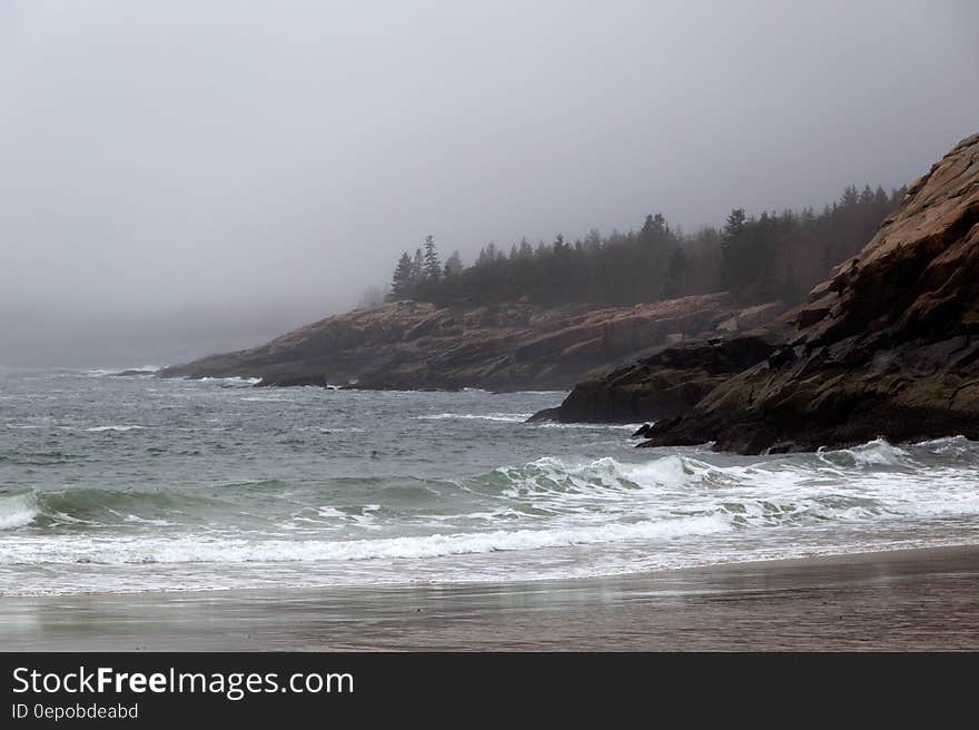 Mountain Surrounding Bodies of Water Cloudy Skies during Daytime