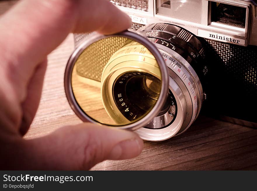 A person holds a filter against a camera. A person holds a filter against a camera.