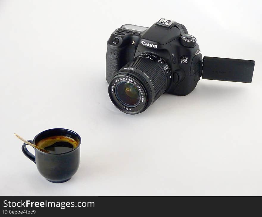 Black Canon Dslr Camera in Front of Coffee in Black Ceramic Teacup