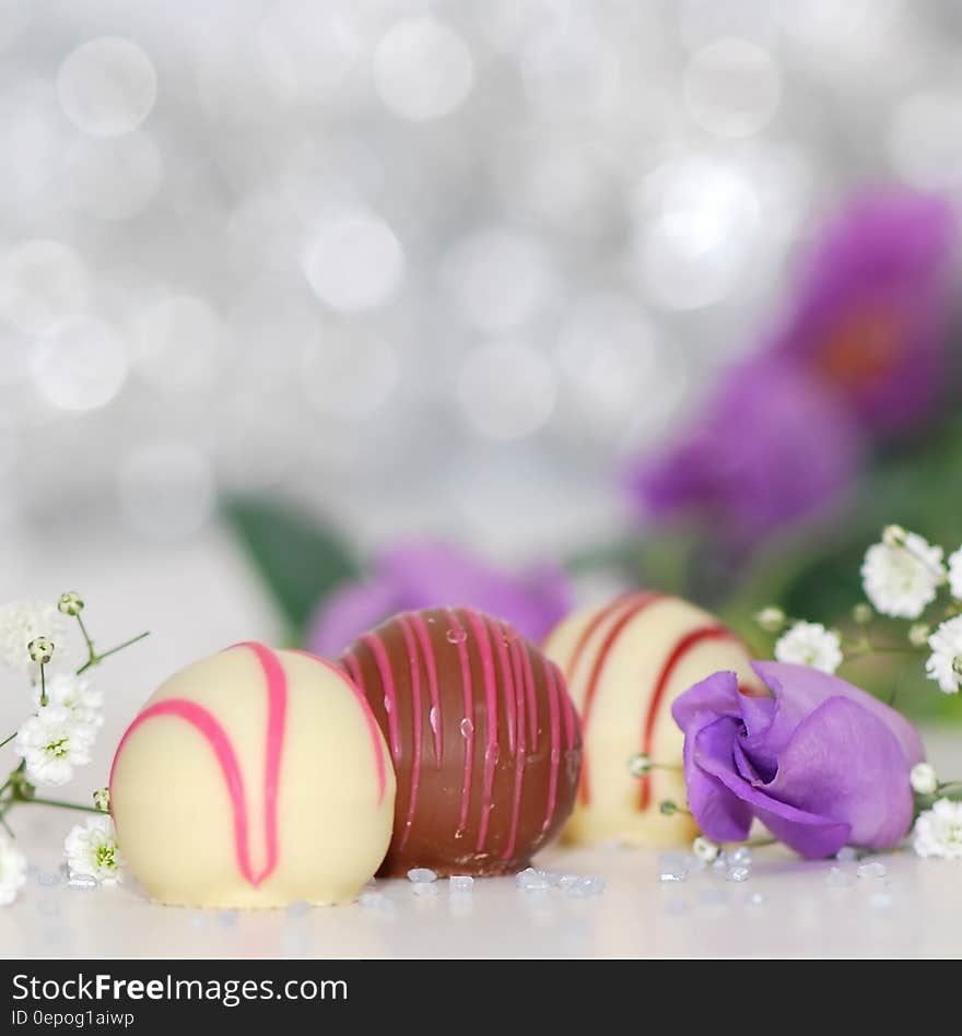 White and Chocolate Sweets With Purple Petal Flower Photo