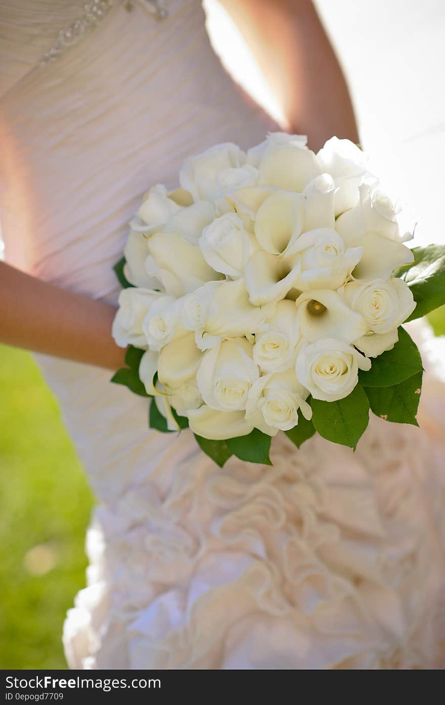 Woman in Wedding Dress Holding White Flower Bouquet